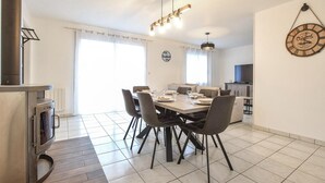 Un comedor moderno con una mesa de madera, sillas grises y una lámpara colgante.