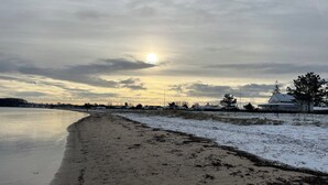 Ein Strand mit einem Haus im Hintergrund.