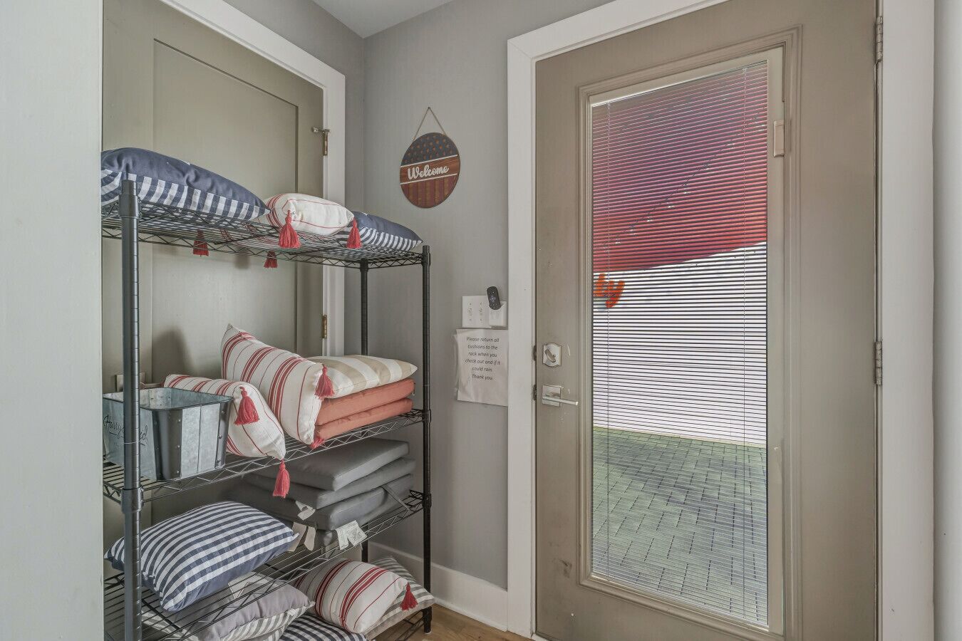A room with bunk beds, a welcome sign, and a door with a window.