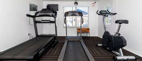 A gym with treadmills, a stair climber, and an elliptical machine.