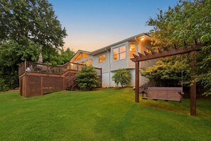 A two-story house with a deck, a swing, and a well-maintained lawn. - The Goldeneye Getaway with Dock! (Gainesville)
