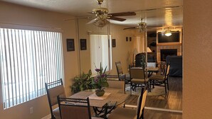 A dining area with a round table, chairs, and a ceiling fan. - Serene 2-bedroom 2-bath condo with AC in Bullhead City (Bullhead City)