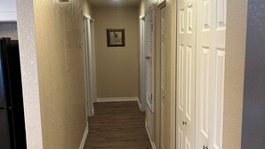 A hallway with wooden flooring, white doors, and a ceiling light. - Serene 2-bedroom 2-bath condo with AC in Bullhead City (Bullhead City)