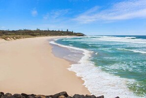 Une plage avec un rivage sablonneux et des vagues.