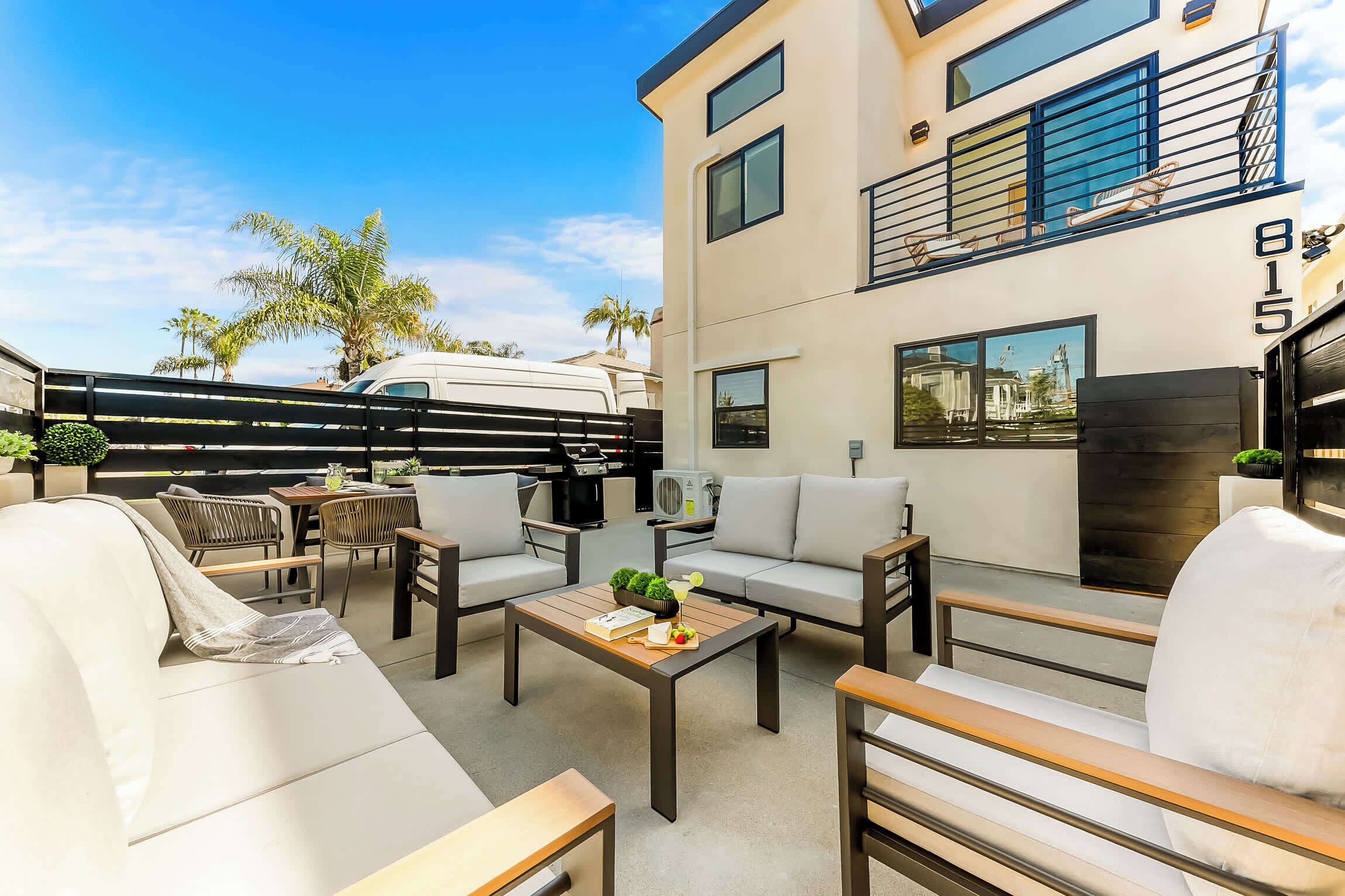 A modern outdoor living area with a sofa, chairs, and a table.
