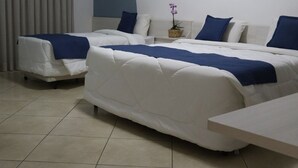 Una habitació d'hotel amb un llit, un sofà, una taula petita i una planta en test.