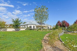 A house with a large lawn, a tree in front, and a clear blue sky. - Luxe Countryside Home - Amazing Views, Sleeps 6 (Byng)