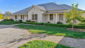 A two-story house with a covered porch, a driveway, and a well-maintained lawn.