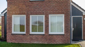 A brick house with three windows and a dark door. - Pet friendly home in Witmarsum with WiFi (Witmarsum)