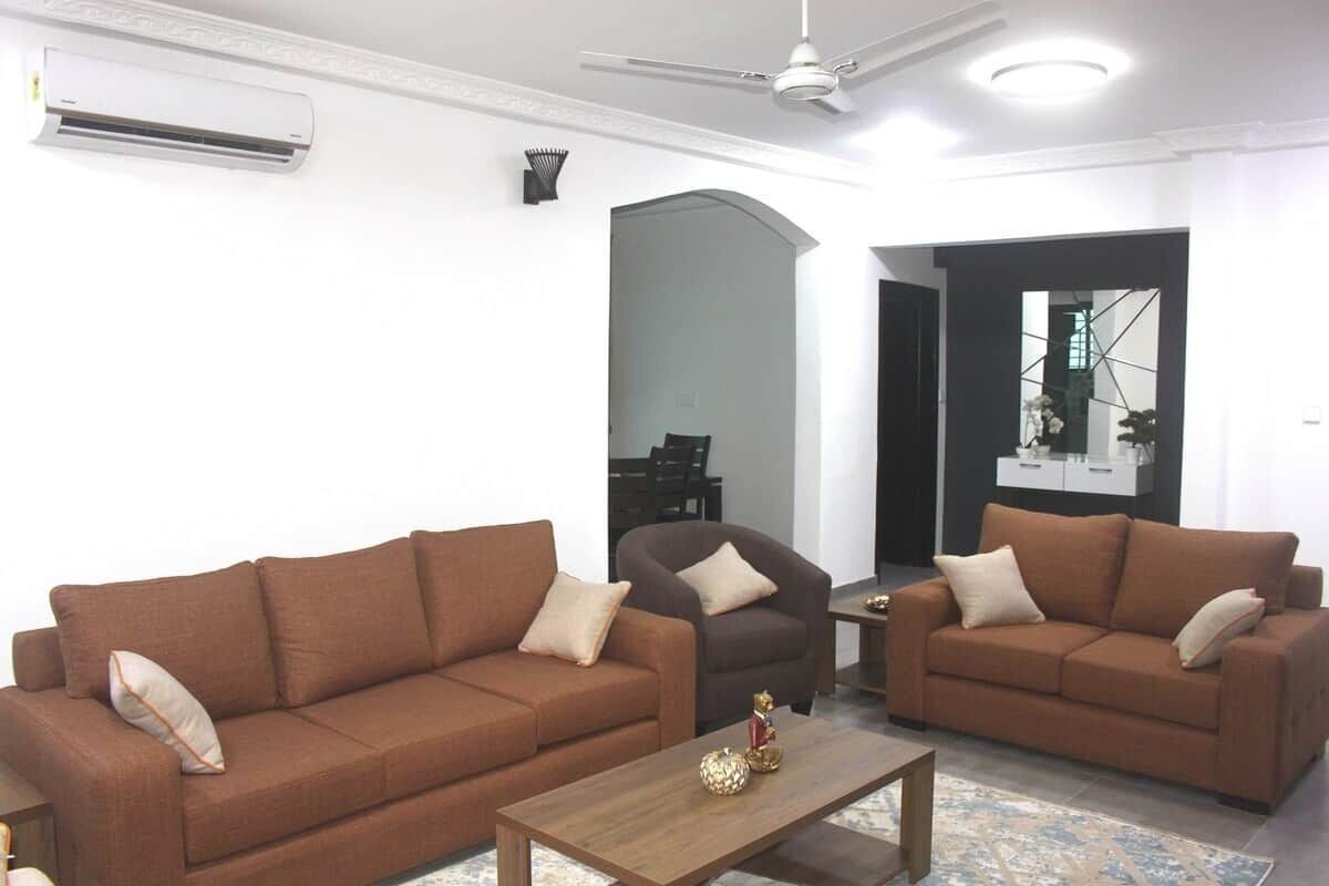 A living room with two sofas, a coffee table, and a ceiling fan.