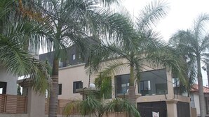 Um edifício moderno com vários andares, janelas amplas e uma varanda.
