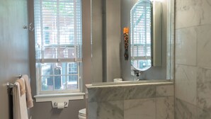 A bathroom with a bathtub, a toilet, a window, and a mirror. - 2-Bdr 2.5Ba House in Enchanting Philadelphia Neighborhood, AC & Private Backyard (Philadelphia)