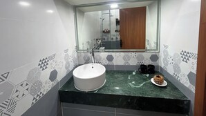 A bathroom with a white sink, a mirror, and patterned tiles. - MINH MINH NAM 3 HOTEL (Can Tho)