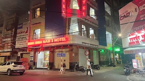 A hotel with a prominent red neon sign, multiple floors, and a visible entrance. - MINH MINH NAM 3 HOTEL (Can Tho)