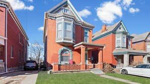 A Victorian-style house with a prominent bay window, a front porch, and a brick facade. - Charming KC 2BR 1 BATH Downtown Access In-Unit Laundry (Kansas City)