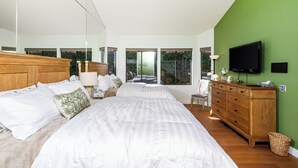 A bedroom with a large bed, a wooden dresser, a television, and large windows. - Hacienda-Resort Style-Golf, Music, & Art Paradise in La Quinta, PGA West Stadium (La Quinta)