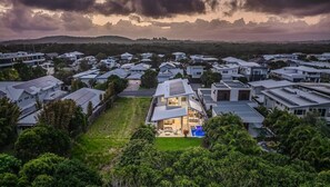 A residential area with modern houses, a swimming pool, and lush greenery.