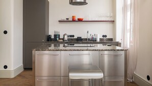 Eine moderne Küche mit Edelstahlgeräten, einer Granit Arbeitsplatte und einer eingebauten Bank.