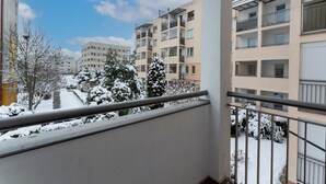 Ein Balkon mit Blick auf schneebedeckte Gebäude und Bäume.