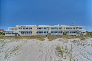 A beachfront hotel with multiple balconies and a sandy beach in front. - Ocean Front 3 bed 3 bath sleeps 12 & Pet Friendly (Panama City Beach)