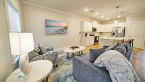 Ein modernes Wohnzimmer mit einer Couch, einem Couchtisch und einem Gemälde an der Wand.