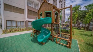 A playground with a slide, climbing structures, and a wooden playhouse. - Studio next to Giovanni Metro Station | Vibra | Morumbi Stadium (São Paulo)