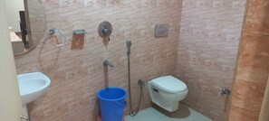 A small bathroom with a toilet, bidet, and sink. - Hotel Parbati International (Asansol)