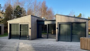 A modern building with large glass doors and a wooden deck. - VillaVilla 924 - Marielyst, Lolland/Falster/møn (Væggerløse)