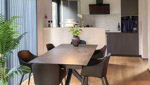 A modern dining area with a rectangular table, six chairs, and a vase with flowers. - VillaVilla 924 - Marielyst, Lolland/Falster/møn (Væggerløse)
