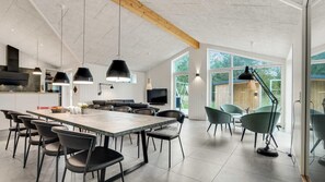 A modern kitchen with a large dining table, black chairs, and pendant lights. - VillaVilla 944 - Blokhus, Nordjylland (Blokhus)