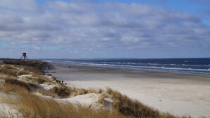 A beach with dunes, a red structure, and the ocean. - VillaVilla 944 - Blokhus, Nordjylland (Blokhus)