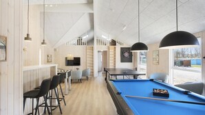 A pool table with a blue felt surface, a dartboard, and a television mounted on the wall. - VillaVilla 933 - Østersøbadet, Lolland/Falster/Møn (Rødby)