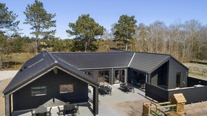 A modern building with a sloped roof, large windows, and outdoor seating area. - VillaVilla 933 - Østersøbadet, Lolland/Falster/Møn (Rødby)