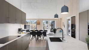 A modern kitchen with a dining area, large windows, and a view of the outside. - VillaVilla 933 - Østersøbadet, Lolland/Falster/Møn (Rødby)