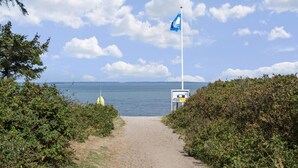 A coastal path leading to the sea with a flagpole and a signboard. - VillaVilla 921 - Skåstrup Strand, Fyn og øer (Bogense)