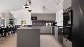 A modern kitchen with a central island, pendant lighting, and built-in appliances. - VillaVilla 921 - Skåstrup Strand, Fyn og øer (Bogense)