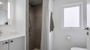 A bathroom with a shower, a toilet, a towel rack, and a window. - VillaVilla 922 - Faaborg, Fyn og øer (Faaborg)