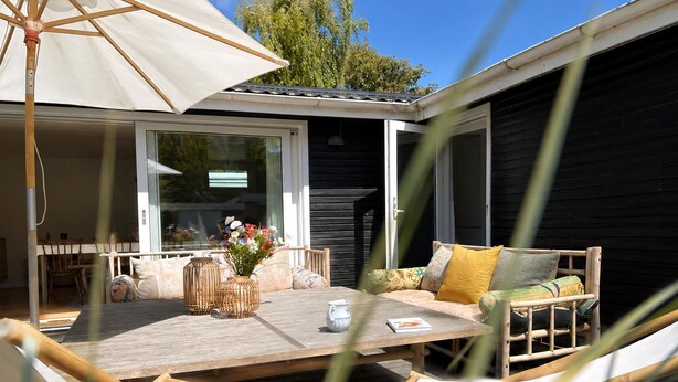 An outdoor seating area with a table, chairs, and a large umbrella. - Cosy cottage, 200 meters from the beach (Nykøbing Sj)