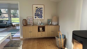A wooden cabinet with decorative items, a framed artwork, and a wicker basket.
