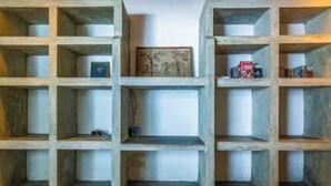 Un mur composé d’étagères ouvertes, sur lesquelles sont disposés divers objets.