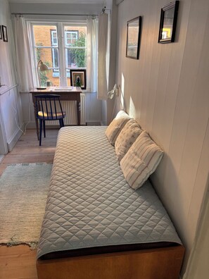 A bedroom with a bed, a desk, and a chair. - Historic townhouse in the heart of Ærøskøbing. (Ærøsk øbing)