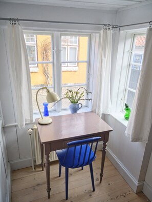 A room with a table, chair, and a window with curtains. - Historic townhouse in the heart of Ærøskøbing. (Ærøskøbing)