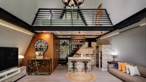 A modern living space with a loft area, kitchen, and dining area. - Intragama Villa (Cisarua)