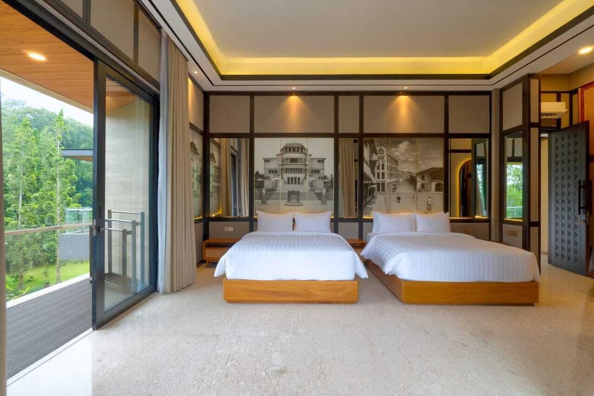 Une chambre moderne avec deux lits, de grandes fenêtres et un balcon.