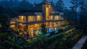 A modern two-story house with a swimming pool, surrounded by lush greenery. - Intragama Villa (Cisarua)