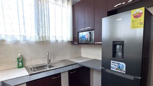 Una cucina moderna con elettrodomestici in acciaio inossidabile, forno a microonde integrato e dispenser per l'acqua.