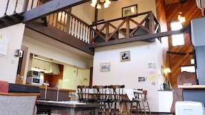 A multi-level wooden interior with a dining area, kitchen, and a staircase. - Heart Land Hills In Noto 11 Akogare No Log House (Shika)