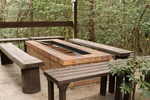 A picnic area with a brick grill and wooden benches. - Heart Land Hills In Noto 11 Akogare No Log House (Shika)