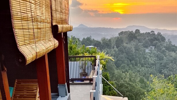 A balcony with a view of a mountainous landscape, a wooden bench, and a metal railing. - Awan Cita Villa Munduk (Seririt)