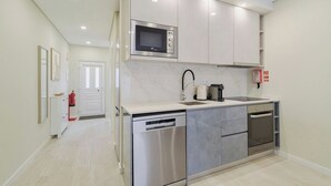 Cocina compacta equipada con lavavajillas, horno, microondas y cafetera.